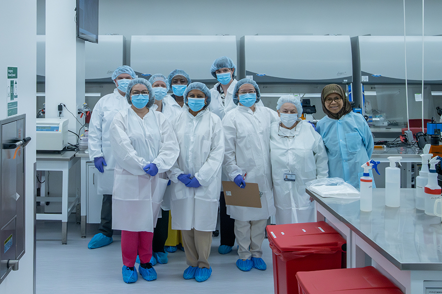 People in PPE visit MCC's biotech lab